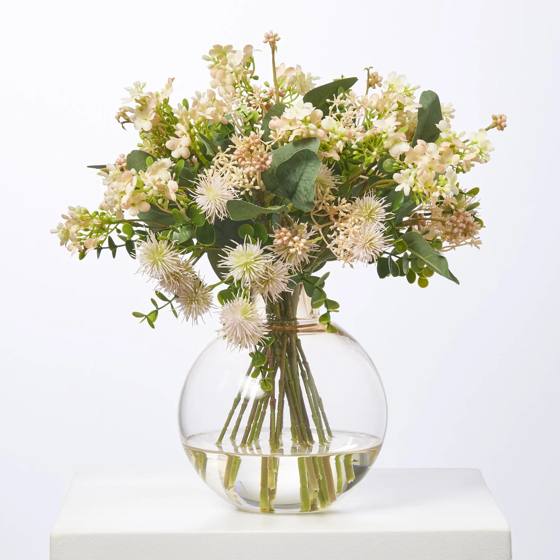 Fuzzy Navel - Peach Thistle Pods & Blush Waxflower with Eucalyptus in Round Ball Amber Vase